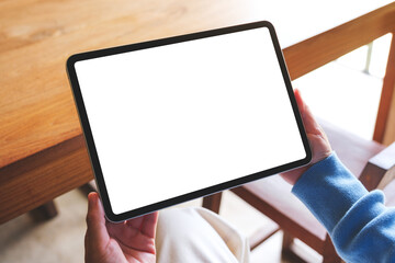 Mockup image of a woman holding digital tablet with blank white desktop screen
