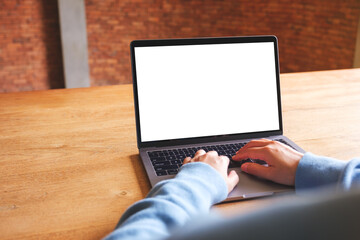 Mockup image of a woman using and typing on laptop computer with blank white desktop screen