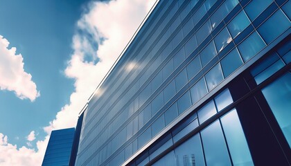 Obraz premium Capturing the Reflective Beauty of Skyscrapers and Office Buildings against a Blue Sky with White Clouds