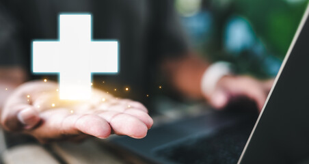 insurance, supporting, health, financial, life, life insurance, investment, technology, assurance, retirement. typing with one hand, holding red cross icon symbolizing insurance and healthcare.