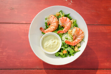 Shrimp Salad. Healthy Seafood Caesar Salad with prawns on the wooden table.top view.