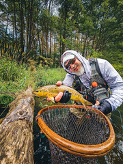 the angler holds a beautiful trout in his hand