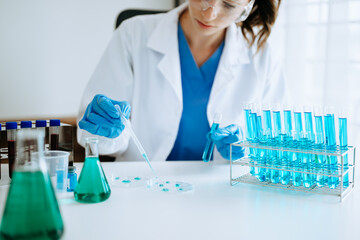 Fototapeta premium Modern medical research laboratory. female scientist working with micro pipettes analyzing biochemical samples, advanced science chemical laboratory for medicine.