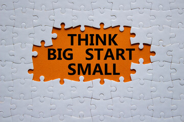 Think big start small symbol. Concept words Think big start small on white puzzle. Beautiful orange...