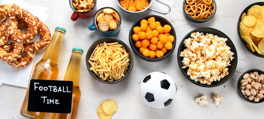 Beer bootles,  snacks and ball on  table.