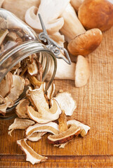 Cut pieces of mushrooms in basket, on wooden background, near fresh mushrooms