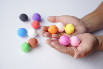 Close up hands holds colordful plasticine balls. Concept, alzheimer, weak muscle patients...