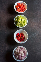 View from top of green salad ingredients in bowls on a background. Selective focus.