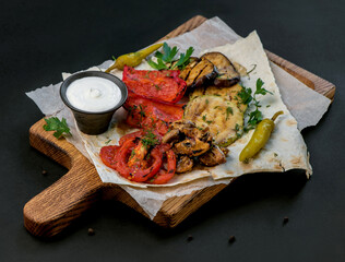 Fried vegetables on a cutting board on a dark wooden background