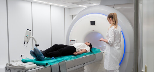 Female patient undergoing MRI - Magnetic resonance imaging in Hospital. Medical Equipment and Health Care - obrazy, fototapety, plakaty
