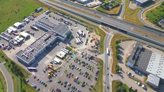 Aerial view of goods warehouse. Logistics center in industrial city zone from above. Aerial view of trucks loading at logistic center