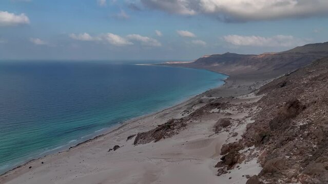 Calm Blue Sea Of Arher Beach With Sand Dunes On The Mountain In Socotra Island, Yemen. - aerial