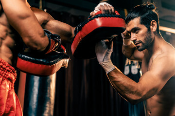 Asian and Caucasian Muay Thai boxer unleash upper cut punch attack in fierce boxing training...