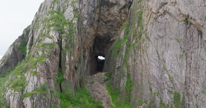 Drone reveal wide large hole passage through Torghatten mountain; down crane