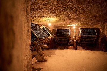 Wine bottles aging in caves in France at Monmousseau winery