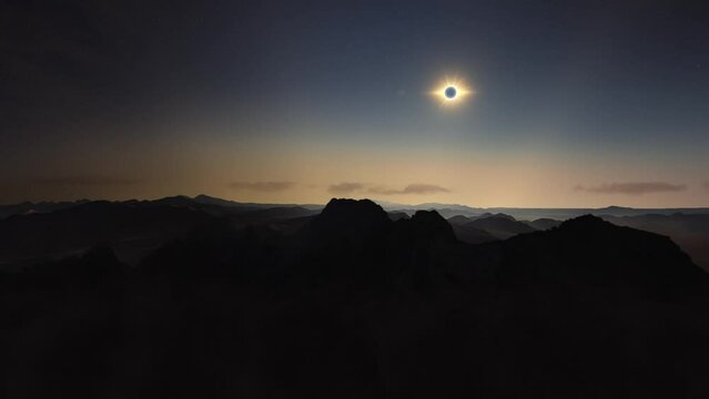 Parallax above mountains as eclipse totality moment of moon on sun flares