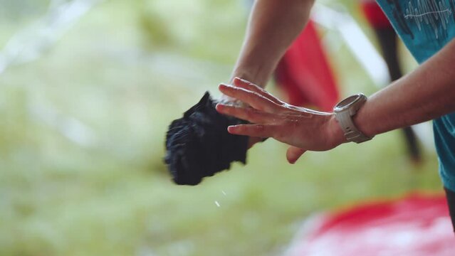 Hands squeeze water out of a T-shirt, squeeze sweat out of a T-shirt, shooting in slow motion
