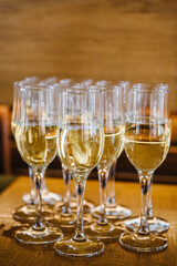Champagne. Many glass of white wine. Glasses of champagne on table bar. Buffet. Celebration of birthday, baptism, wedding, corporate party. Catering service. Serves glasses of sparkling wine. Closeup