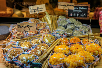 Coated goat cheese rounds with chives, herbs, dried apricots and raisins at an artisanal cheese shop in the old town or Vieil Antibes, South of France