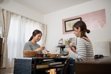 Fototapeta premium 自宅で食事をする二人の女性