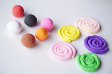 Colorful plasticine were sculpted into different shapes, balls and rolls. Concept, materials or tool for practicing imagination and brain development for kids.       - obrazy, fototapety, plakaty