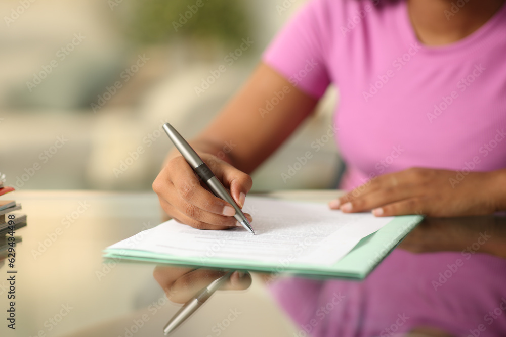 Wall mural Black woman hand filling form on a desk