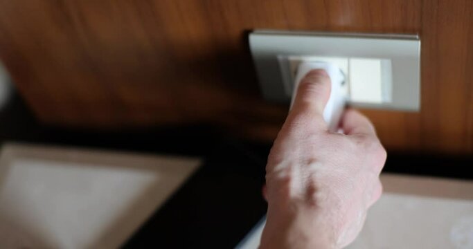 Man hand inserting plug into socket at home closeup 4k movie slow motion. Energy saving concept