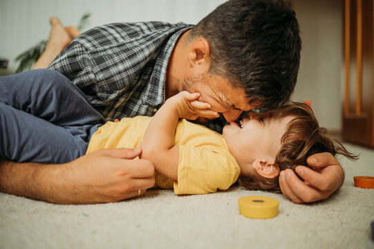 Smiling father spending leisure time playing at home