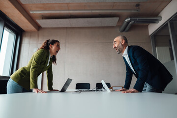 Businesswoman arguing with businessman at desk in office