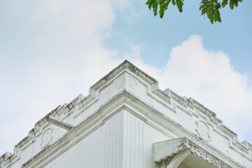 A white vintage architecture against blue cloudy sky