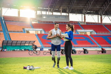 Asian athlete with prosthetic blades and trainer workout in stadium.