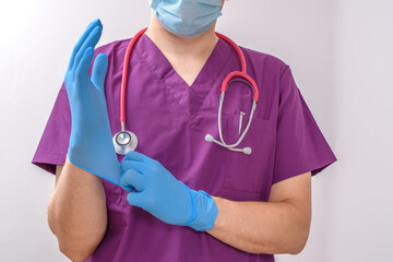 Lekarz chirurg zakładający rękawiczki do zabiegu - obrazy, fototapety, plakaty