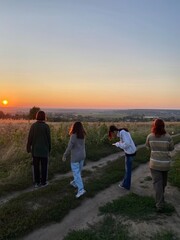 a company of people at sunset