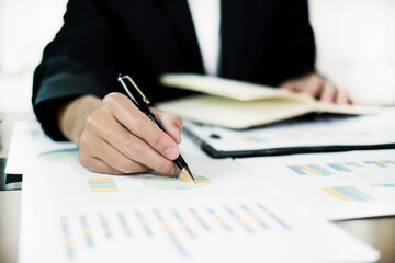 The business hand sits at their desks and calculates financial graphs showing the results of their investments planning the process of successful business growth