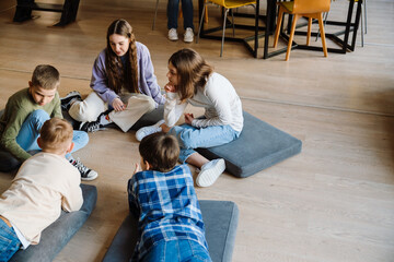 Group of kids discussing something while sitting in classroom