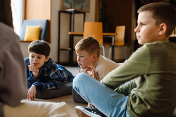 Group of kids discussing something while sitting in classroom