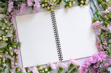 Empty white notebook and pencil with pink flowers on white background.