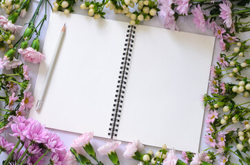 Empty white notebook with pink flowers on white background.