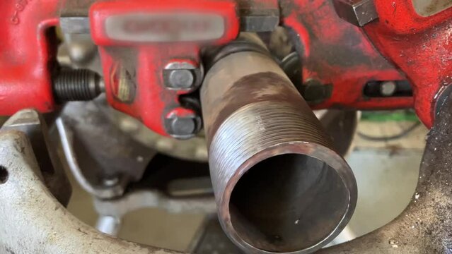 The Art of Metalwork: Threading a Steel Pipe Using a Hat and Cooling Oil"