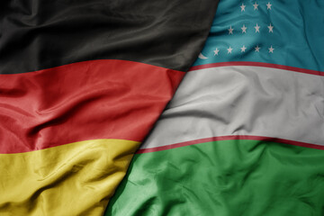 Obraz premium big waving realistic national colorful flag of germany and national flag of uzbekistan .