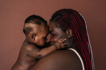 Beautiful african mother and her baby touching foreheads