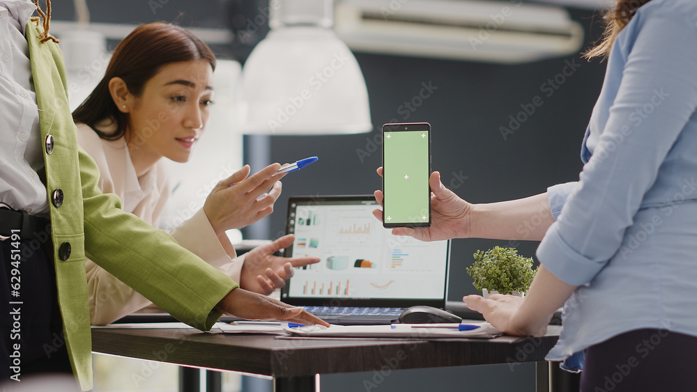 Wall mural diverse group of employees working with greenscreen on smartphone, using isolated display with chrom