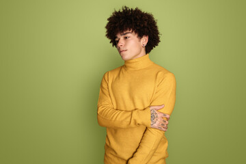 Fototapeta na wymiar Cool young ethnic male model standing against green background