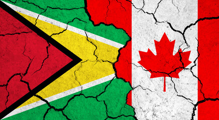 Flags of Guyana and Canada on cracked surface - politics, relationship concept
