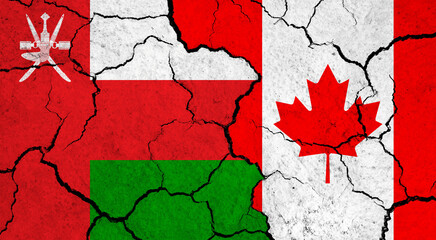 Flags of Oman and Canada on cracked surface - politics, relationship concept