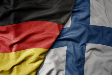 Fototapeta premium big waving realistic national colorful flag of germany and national flag of finland .