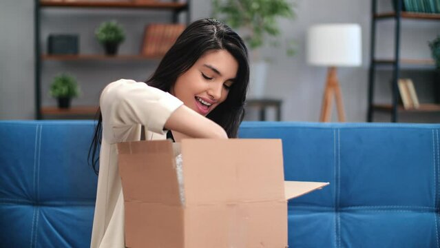 Happy mixed race brunette woman unpacking cardboard box marketplace order online shopping sale