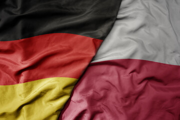 big waving realistic national colorful flag of germany and national flag of poland .