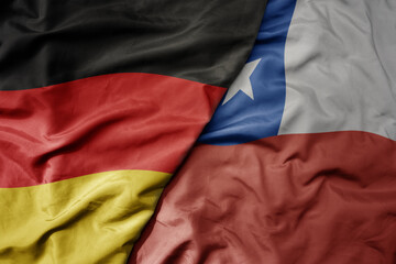 big waving realistic national colorful flag of germany and national flag of chile .