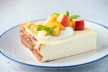 Cheesecake, cottage cheese casserole with mango and cream, closeup view